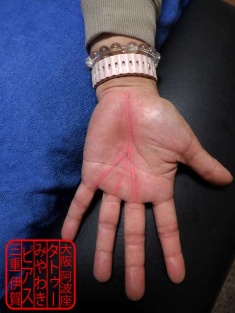 左手のひらにピンク色の覇王線のタトゥー・刺青