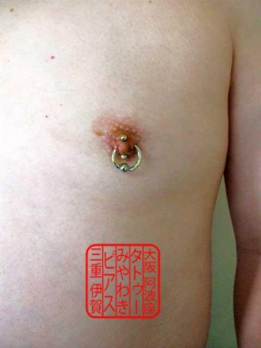 左乳首に水平にリングジュエリー、バーベルで縦に二連でピアッシング。縦のニップルピアッシングはバーティカルニップルピアッシングと言います。